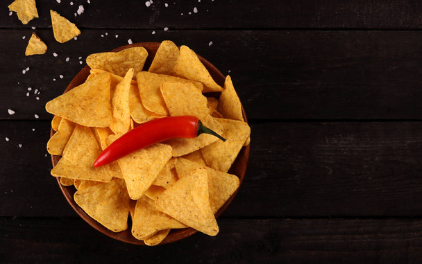 Mexican nachos in Wooden Bowl tortilla chips with chilli pepper and salt, top view and Black Background - Fotoğraf, Görsel