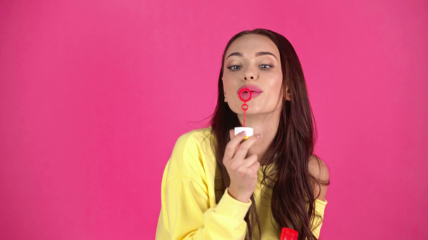 Studio střílet šťastné mladé ženy foukání mýdlové bubliny na Rudé pozadí - Záběry, video