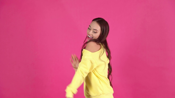 estudio disparar de atractivo feliz joven mujer jugando alrededor y bailando sobre fondo carmesí
 - Metraje, vídeo