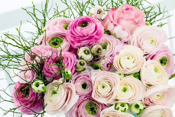 Персидские лютики. На фоне бледно-розовых цветков раннункулуса. Обои, Горизонтальное изображение
 - Фото, изображение