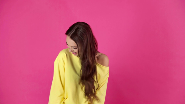 Studio σουτ του ελκυστική χαμογελώντας νεαρή γυναίκα παίζει με τα μαλλιά σε βυσσινί φόντο - Πλάνα, βίντεο