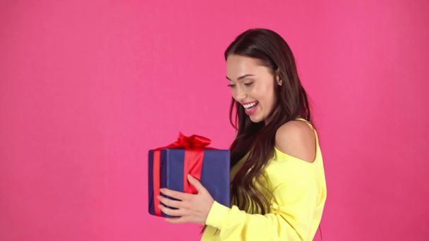 Studio σουτ του όμορφη happy νεαρή γυναίκα λαμβάνει συσκευασία δώρου και απολαμβάνοντας παρόντες - Πλάνα, βίντεο