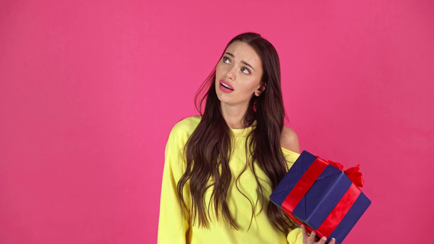 studio shoot van mooie jonge vrouw met luxe-geschenketui en weergegeven: duim omlaag geïsoleerd op crimson boos - Video