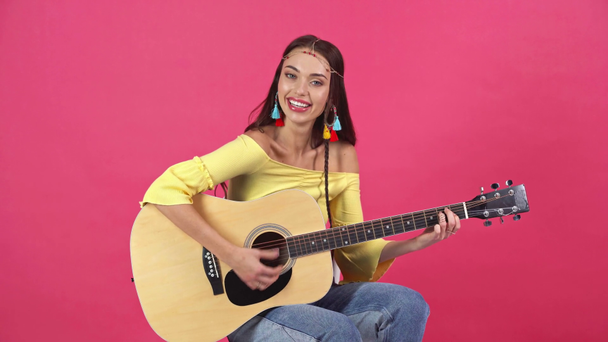 sesión de estudio de la joven feliz tocando la guitarra acústica aislado en carmesí
 - Imágenes, Vídeo