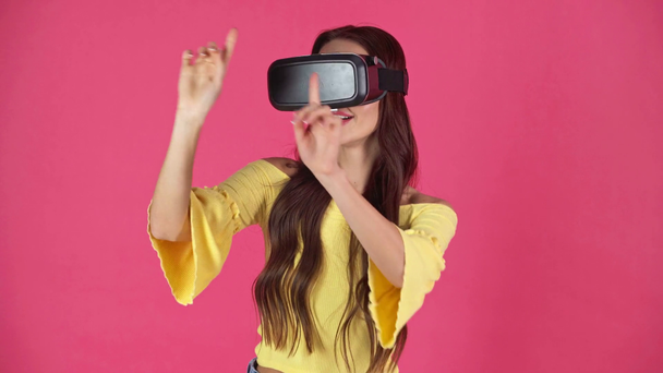 студійний знімок збудженої молодої жінки в гарнітурі віртуальної реальності, що жестикулює ізольовано на малині
 - Кадри, відео