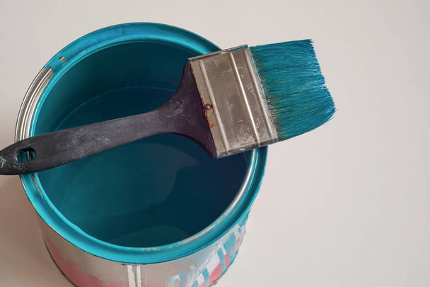 Flautz para pintar grandes superficies sobre una lata de pintura azul
 - Foto, imagen