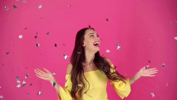 slow motion shoot of happy young woman looking at silver confetti falling down - Footage, Video