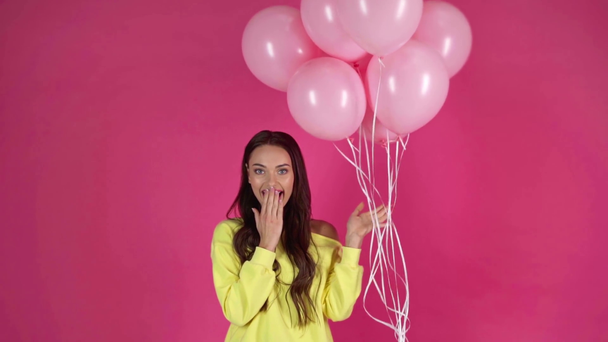 Slow motion schieten van gelukkige jonge vrouw met roze lucht ballonnen - Video