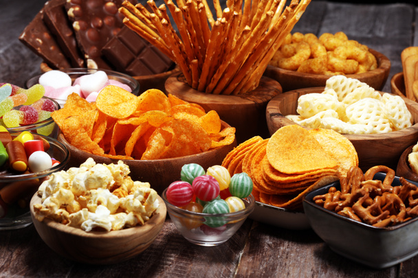 Zoute snacks. Zoutjes, chips, crackers in houten kommen op tafel - Foto, afbeelding