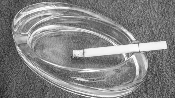 Zeitraffer. Eine Zigarette brennt im Aschenbecher. Schwarz-Weiß-Video. 4k. - Filmmaterial, Video
