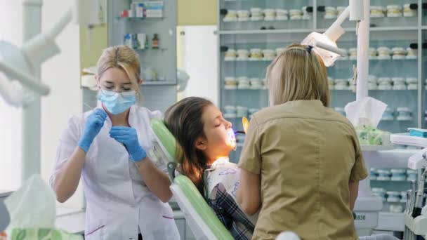 Orthodontiste brille sur les dents avec une lampe photopolymère
 - Séquence, vidéo