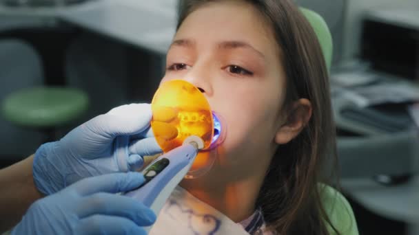 Orthodontist shines on the teeth with a photopolymer lamp - Footage, Video