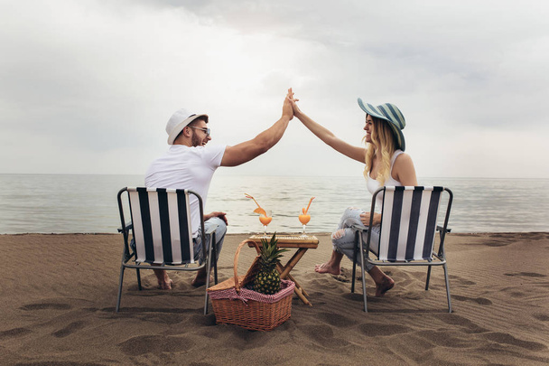 Couple on a deck chair relaxing on the beach. Happy couple enjoy - 写真・画像