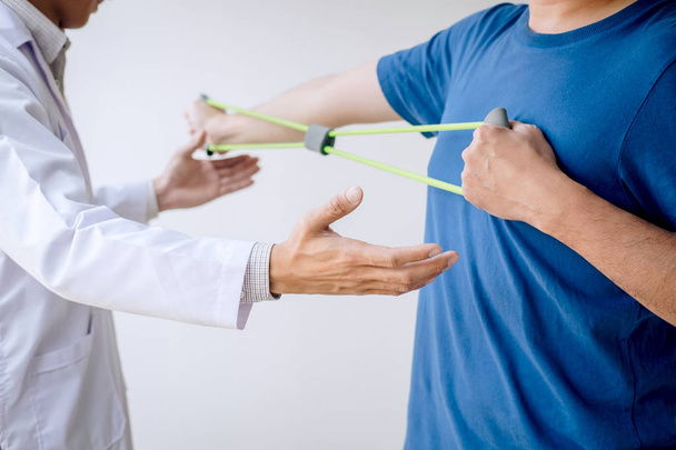 Médico fisioterapeuta que ayuda a un paciente masculino mientras que da exe
 - Foto, Imagen