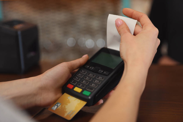 Kobieta przy użyciu karty kredytowej maszyny do bezgotówkowej zapłaty w kawiarni, zbliżenie. Miejsca na tekst - Zdjęcie, obraz