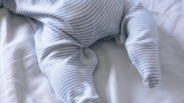 A kisfiú lába mozog. Aranyos boldog 4 hónapos kisfiú feküdt, és játék - Felvétel, videó
