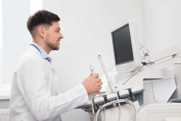 Sonographer operating modern ultrasound machine in clinic - Valokuva, kuva
