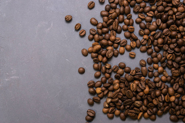 Roasted coffee beans in bulk on a gray concrete background. dark - Photo, Image