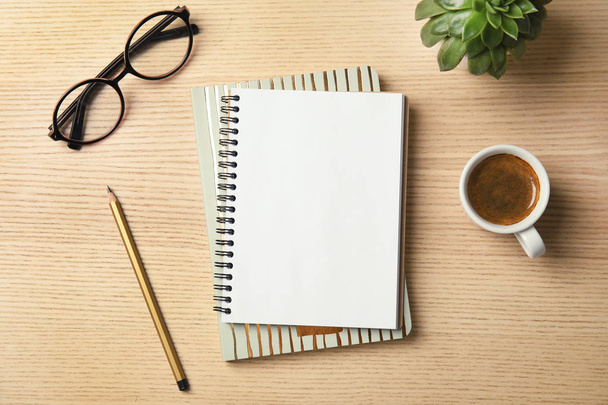 Flat lay composition with notebooks, coffee and glasses on wooden background - Foto, afbeelding