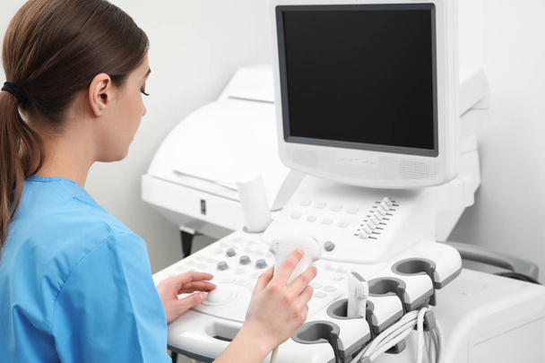 Sonographer operating modern ultrasound machine in clinic - Photo, image