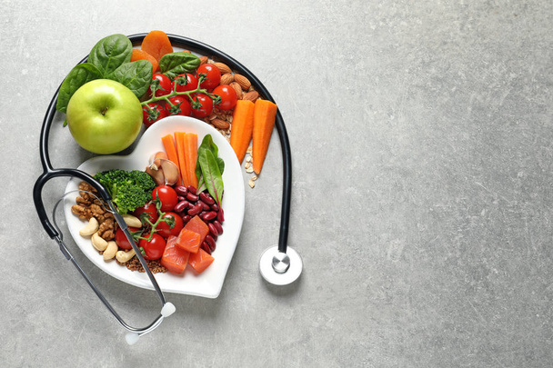 Flat lay composition with plate of heart-healthy diet products and space for text on grey background - Foto, afbeelding