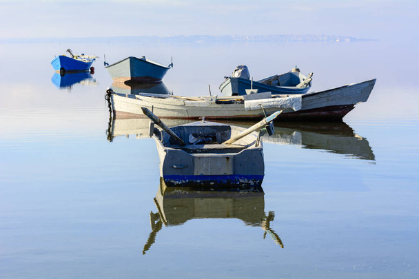 Antiguos barcos de pesca con colores brillantes al amanecer en el lago
. - Foto, imagen