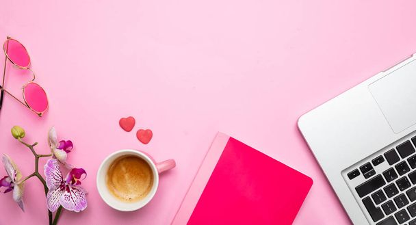 Fiori, tazza di caffè e laptop su sfondo rosa scrivania, spazio copia
 - Foto, immagini