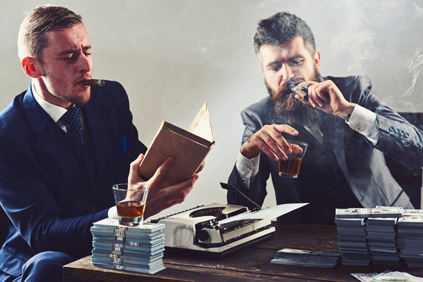 Men of style and status. Business partners with cash money. Businessmen write financial report while drinking and smoking. Money brokers counting profit increase. Successful investment in business - 写真・画像