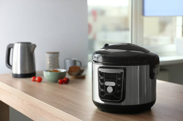 Modern multi cooker and ingredients on table in kitchen, space for text - Foto, Bild