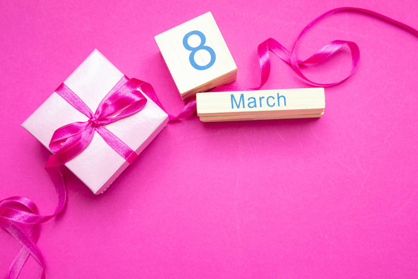 Caja de regalo con cinta y día de la mujer 8 de marzo sobre fondo rosa
 - Foto, Imagen