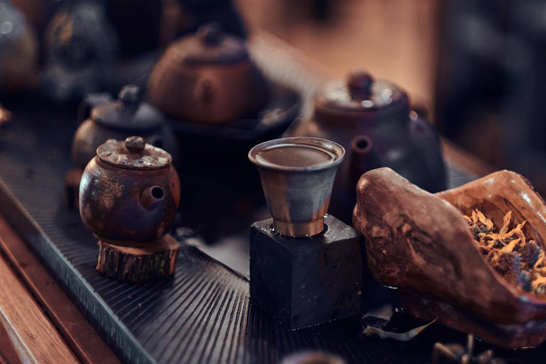 Zubehör, Keramiktassen und Teekannen, trockene Kräuterblätter, alles für die Zubereitung eines natürlichen aromatischen Tees. traditionelle asiatische Teezeremonie - Foto, Bild