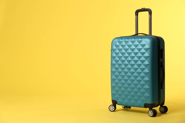 Stylish suitcase on color background. Space for text - 写真・画像