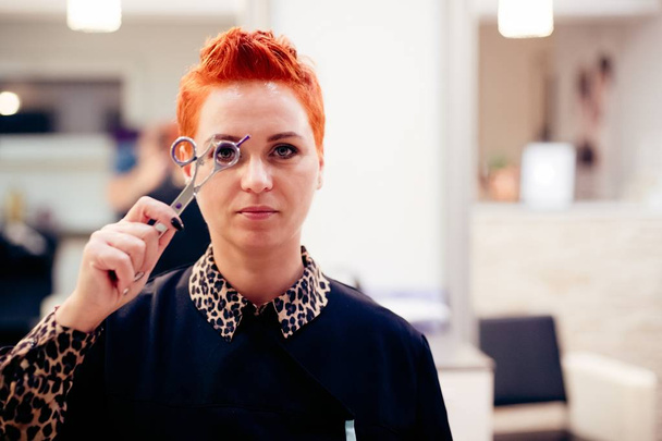Female hairdresser posing with scissors - Foto, afbeelding
