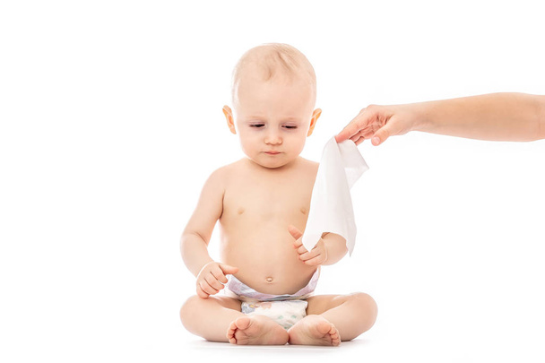 Πορτρέτο του ένα μωρό που παίρνει μια αλλαγή πανών: μαμά σκούπισμα babys κάτω με το μωρό σκουπίζουν απομονωθεί σε λευκό φόντο. έννοια τον καθαρισμό σκουπίστε, αγνό, καθαρό - Φωτογραφία, εικόνα