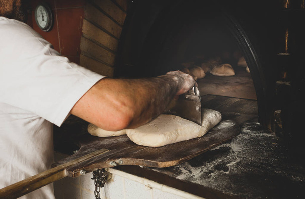 Herstellung von gebackenem Brot mit einem Holzofen in einer Bäckerei. - Foto, Bild