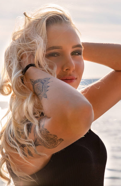 Outdoor-Mode Porträt der schönen blonden Dame am Strand mit Blitz-Tätowierung - Foto, Bild