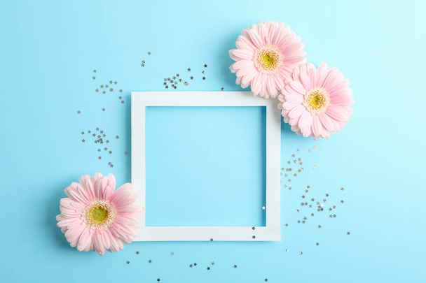 Beautiful gerberas and frame on color background, space for text - Foto, afbeelding