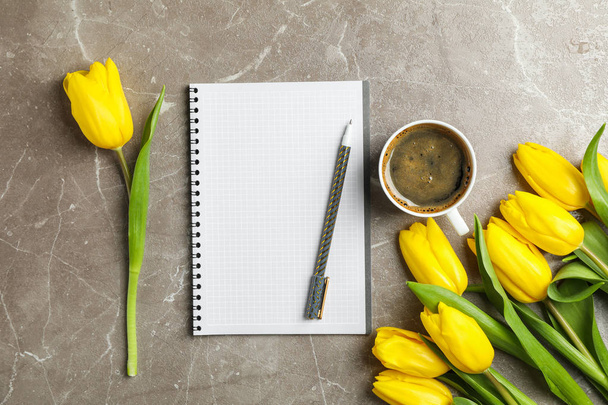 Beautiful tulips, copybook and cup of coffee on grey background - Photo, Image