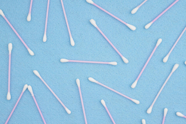Λευκό και ροζ βαμβάκι επιχρίσματα σε φόντο μπλε χαρτί - Φωτογραφία, εικόνα