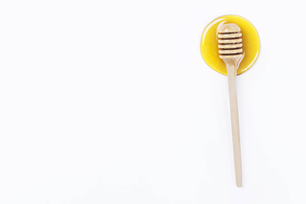 Honey dipper in honey and a jar of honey isolated on light grey background - Foto, Bild