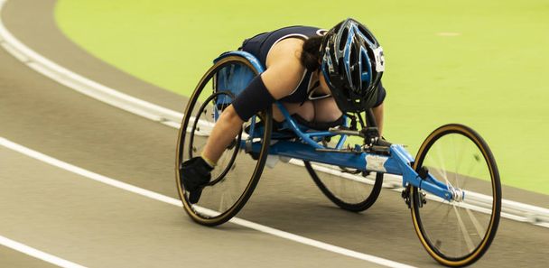 Atleta en silla de ruedas corriendo la milla en el interior
 - Foto, imagen