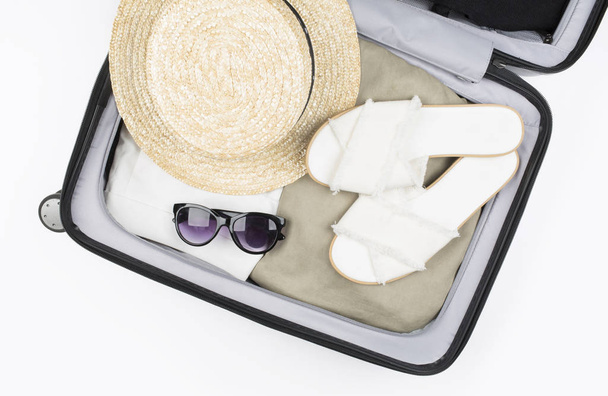 Open suitcase packed for travelling. Hat, glasses, sandals. - Fotografie, Obrázek