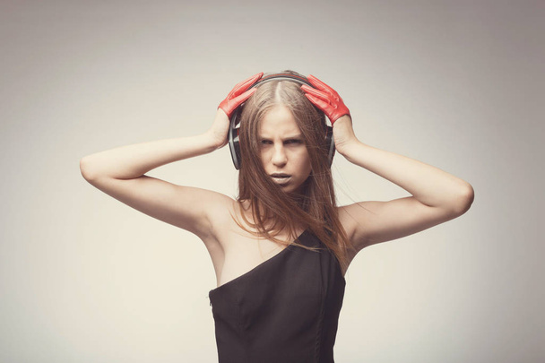 Moda chica bonita escuchando música con auriculares, usando rojo
 - Foto, imagen