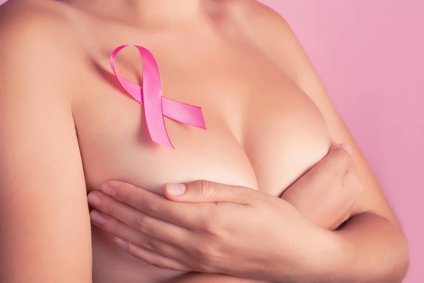 health, medicine, beauty concept - naked woman with Pink Breast Cancer awareness Ribbon. Support of patients with oncology - Photo, Image