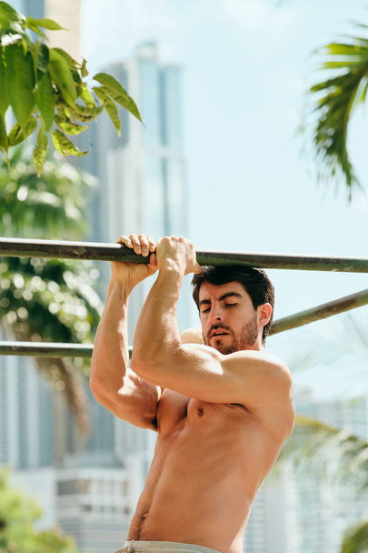 Adult man training ABS buikspieren doen gymnastiek buitenshuis - Foto, afbeelding