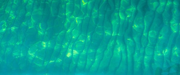 Зелена абстрактна текстура фону смарагдової зеленої морської води. Вид зверху на зелену морську воду з унікальним візерунком. Зелений фон. Поверхня морської хвилі води на узбережжі. Бірюзова вода на мілководді
. - Фото, зображення