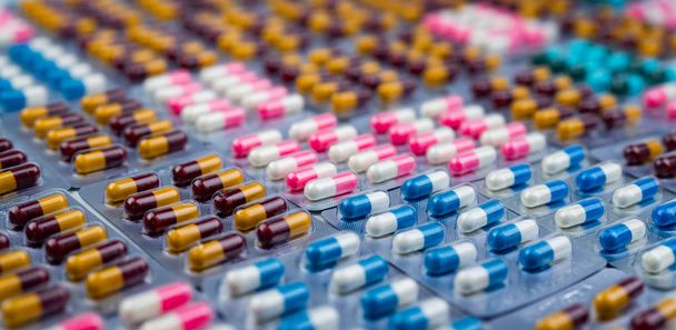 Selektivní fokus na barevné antibiotické tobolka pilulek v blistru. Antibiotické rezistence. Farmaceutický průmysl. Lékárna lékárna pozadí. Komplexní zdravotní péče. Antimikrobiální kapsle. - Fotografie, Obrázek