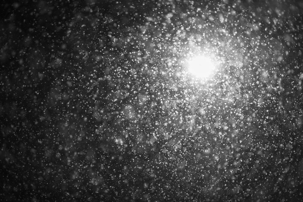 abends beleuchtet eine Straßenlaterne große Schneeflocken. Unerwarteter Frühjahrsschnee - Foto, Bild