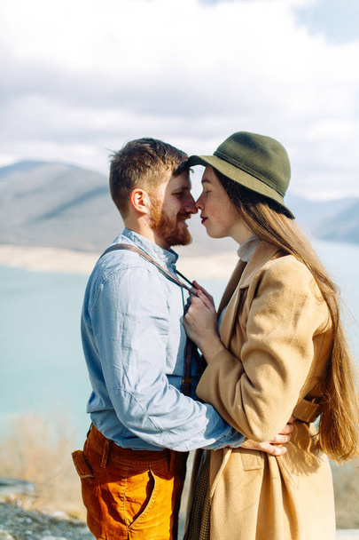 A beautiful couple travels in the mountains of Georgia. Lovestory in nature with a lake. - Photo, image
