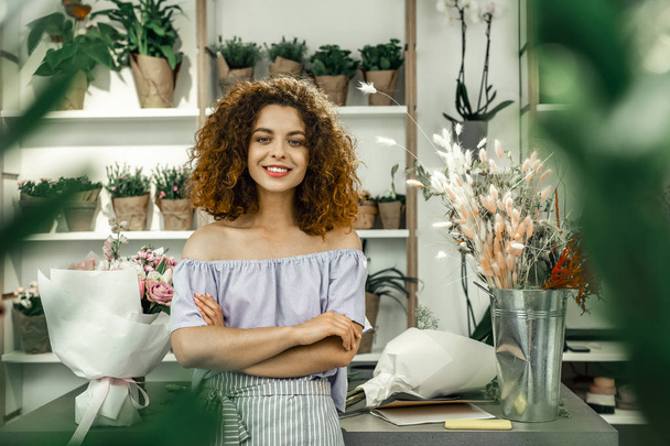 Young appealing student enjoying her part-time job in big floral shop - Фото, зображення